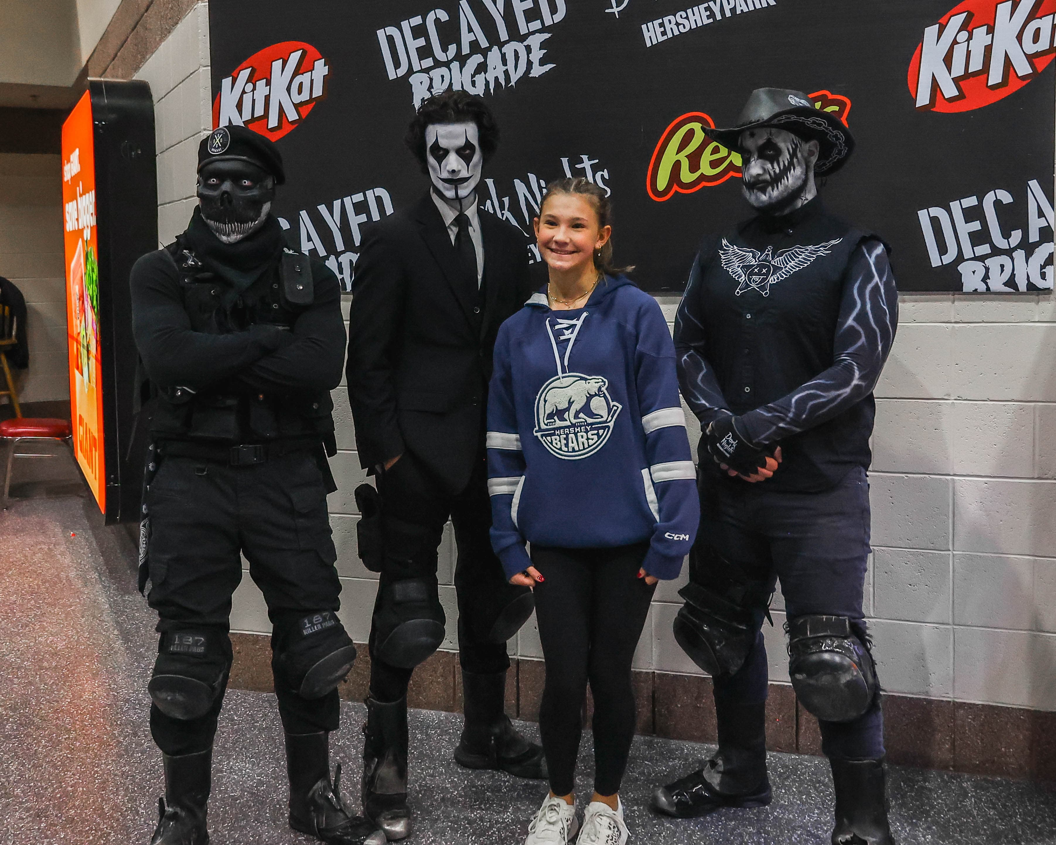 A young fan posing for a picture with scare actors at South End Fan Zone.