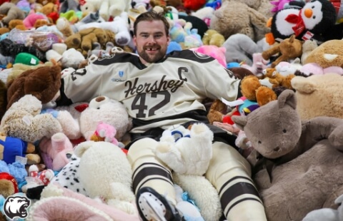 Hershey Bears player in pile of teddy bears