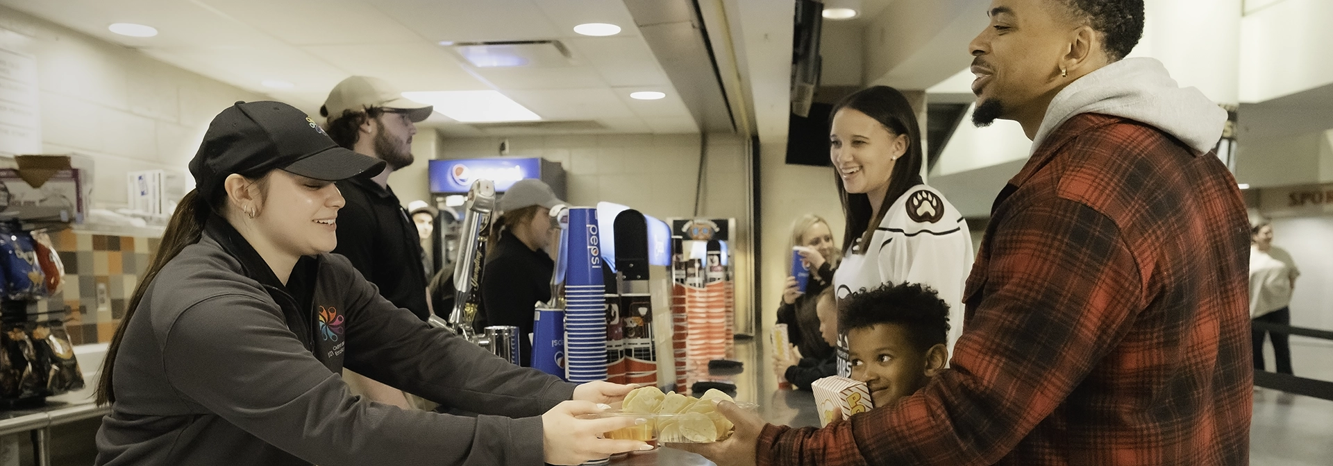 A server handing out food to a guest and his family