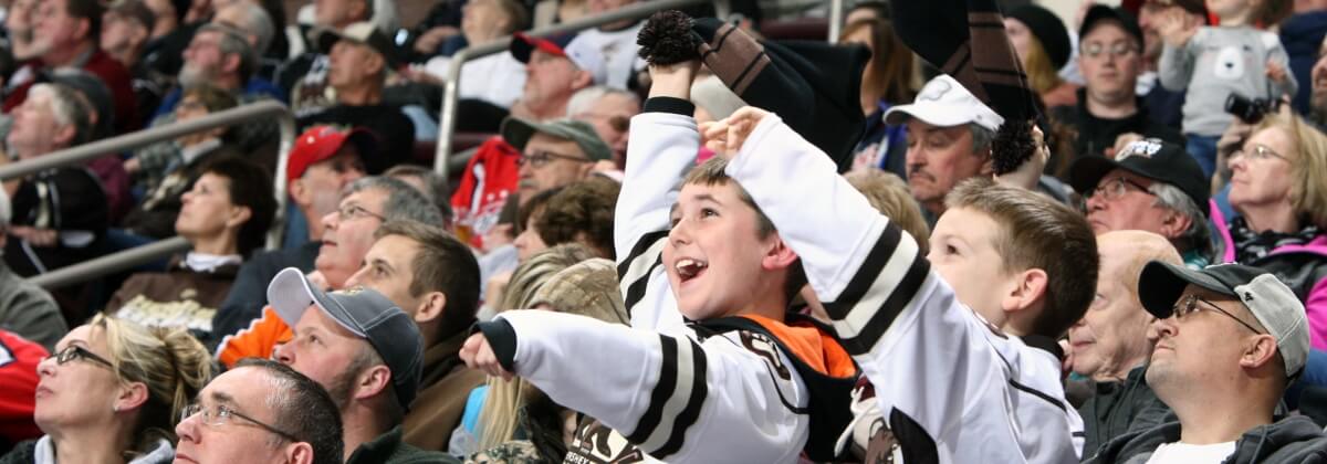 Young boy cheering in crowd with bears shirt