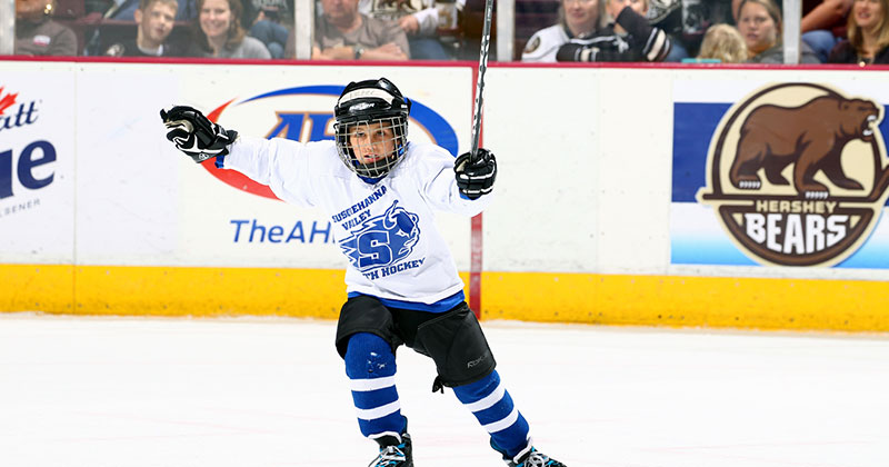 Players and child standing on ice